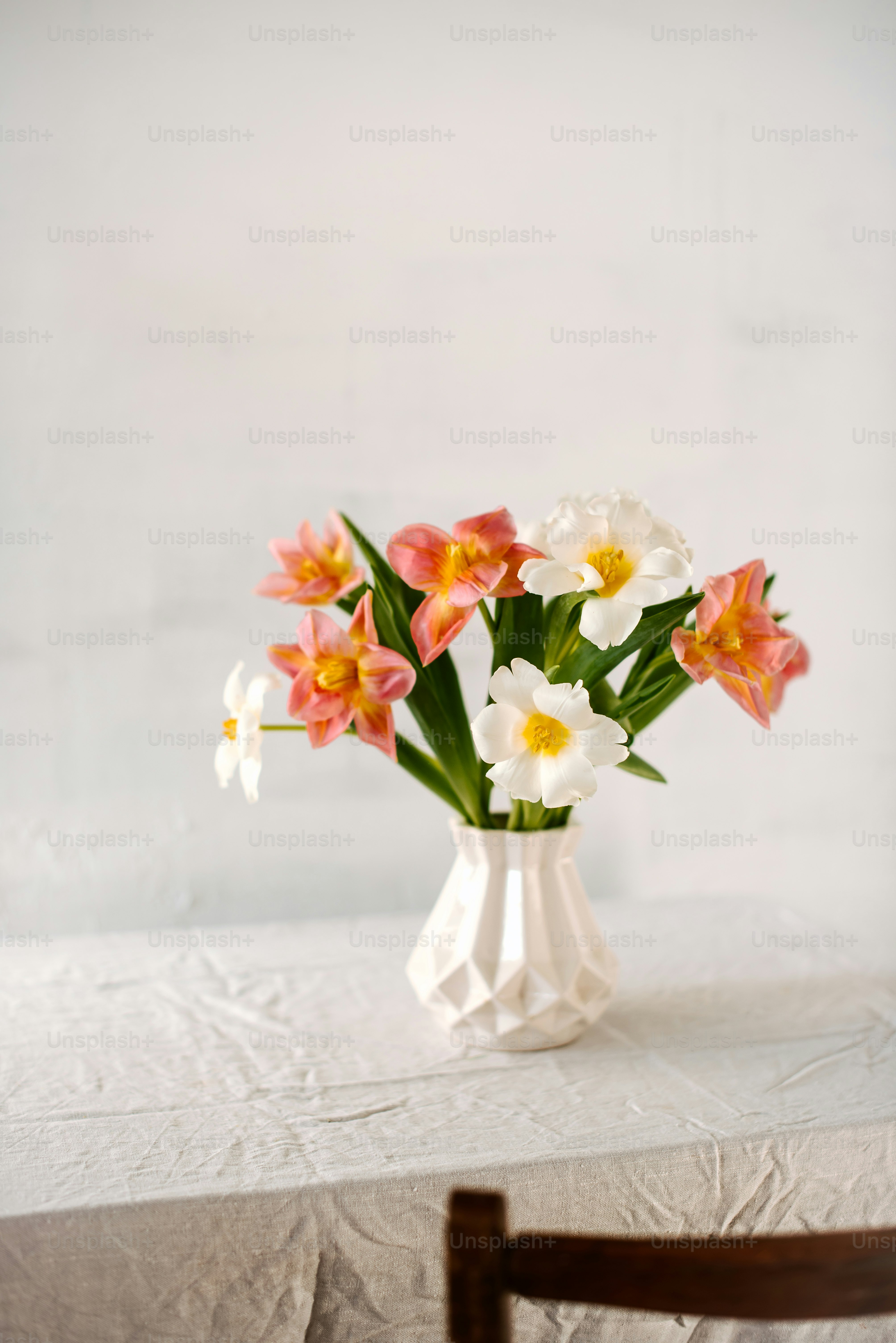 a white vase filled with flowers on top of a table
