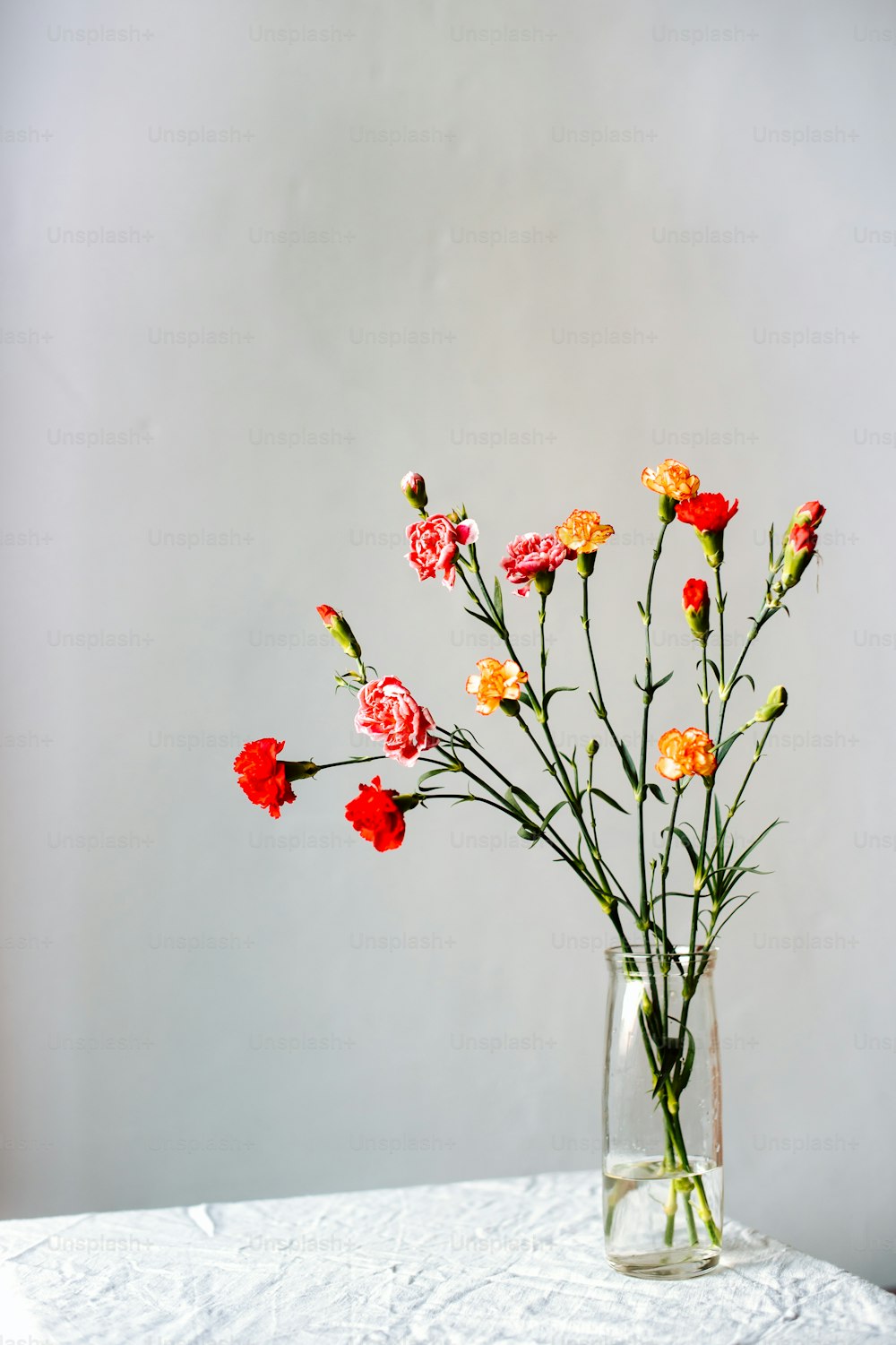 un vase en verre rempli de fleurs sur une table