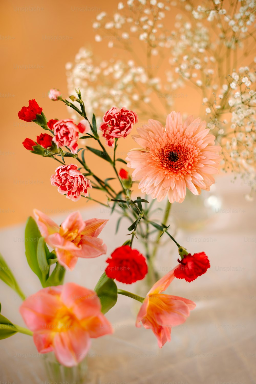 a vase filled with pink and red flowers