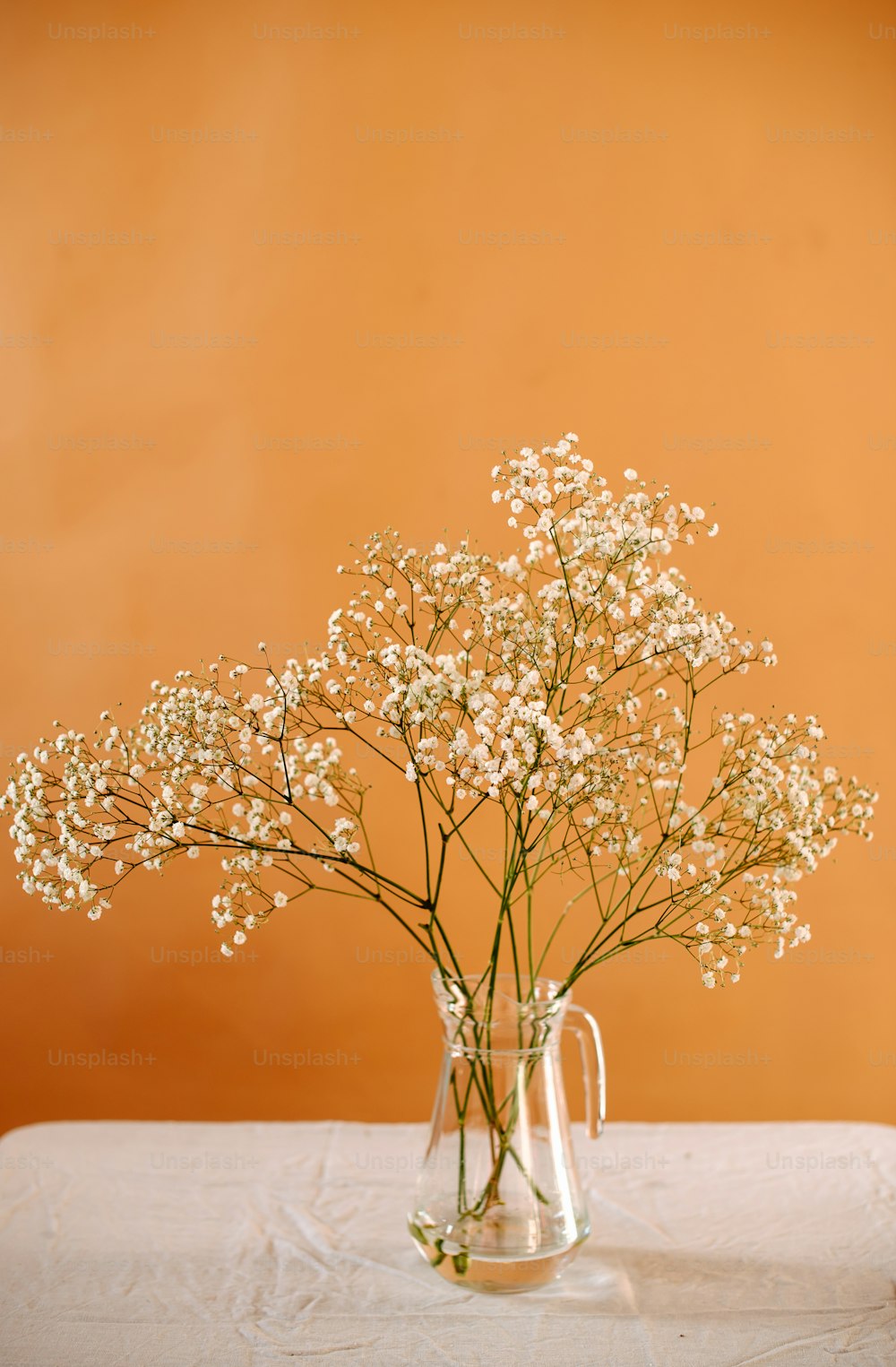 um vaso cheio de flores brancas em cima de uma mesa