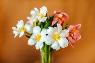 a vase filled with white and pink flowers