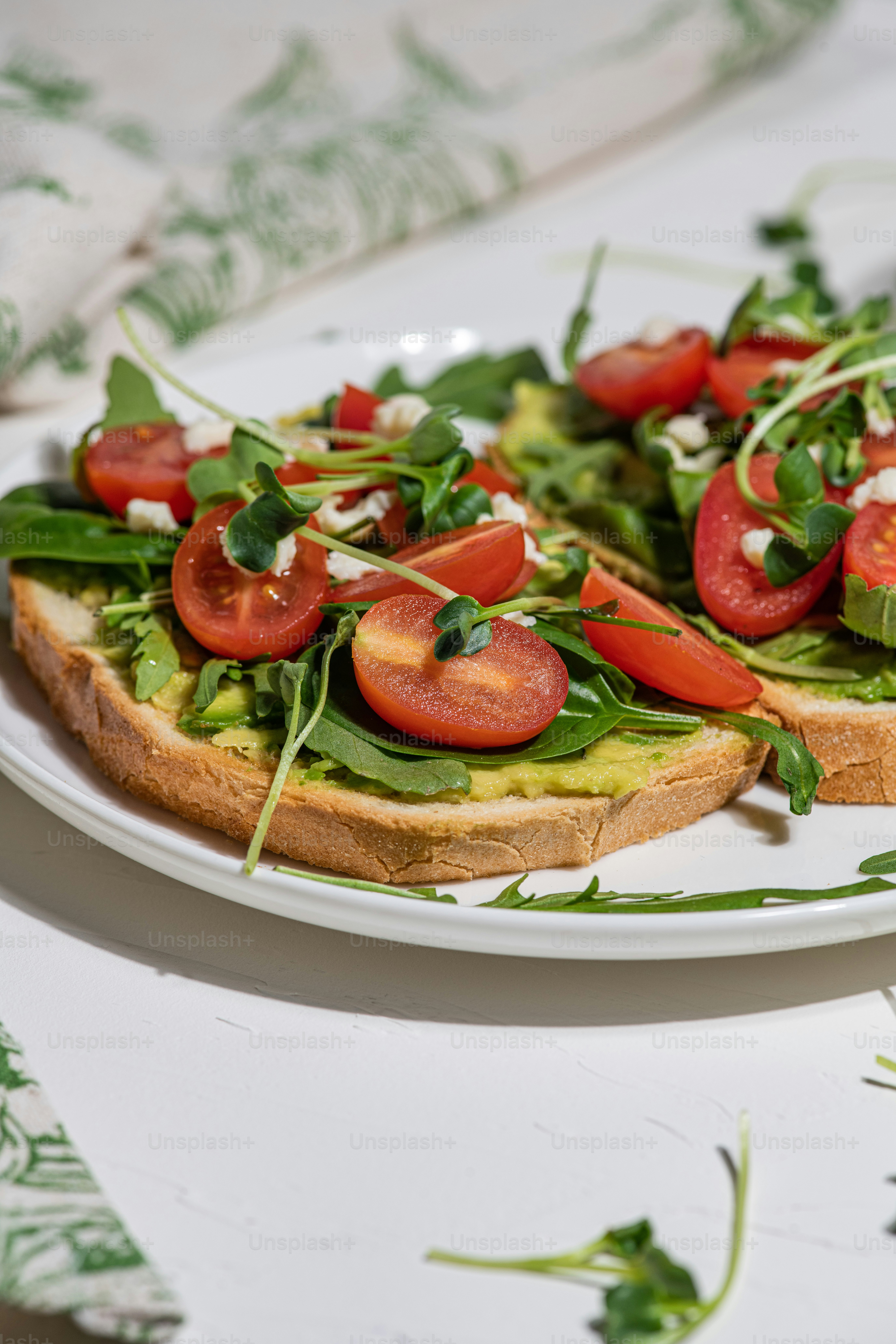 野菜で覆われたパンのスライスをトッピングした白い皿