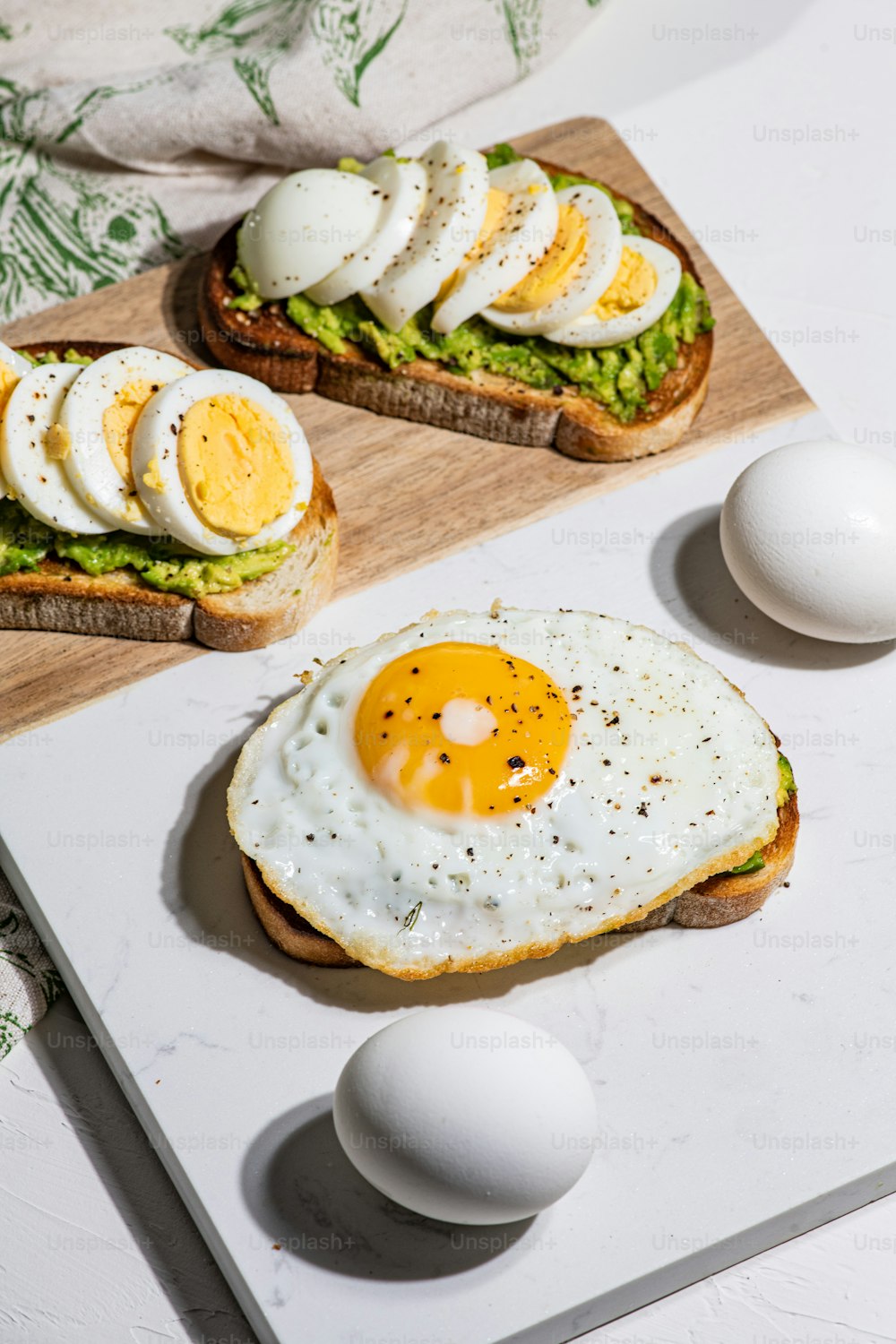 une table garnie d’œufs et de pain grillé sur le dessus d’une planche à découper