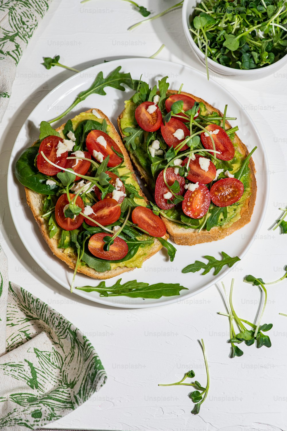 a white plate topped with two open faced sandwiches