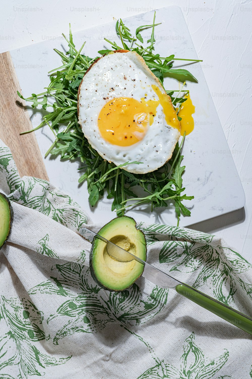 an avocado and an egg on a cutting board
