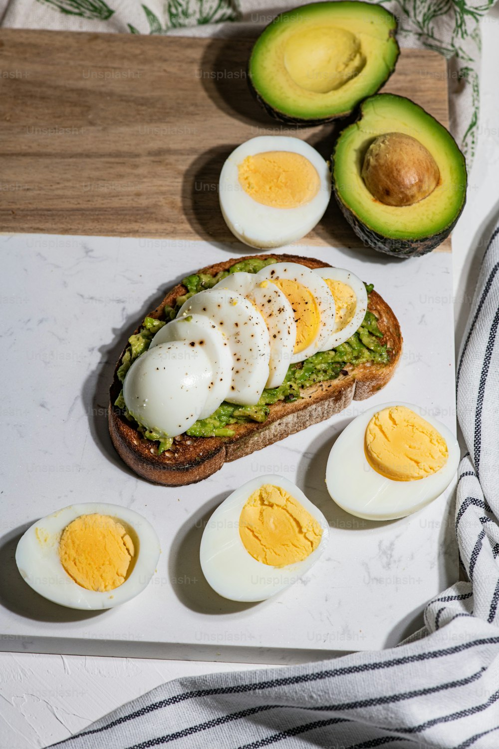 an egg and avocado sandwich on a cutting board