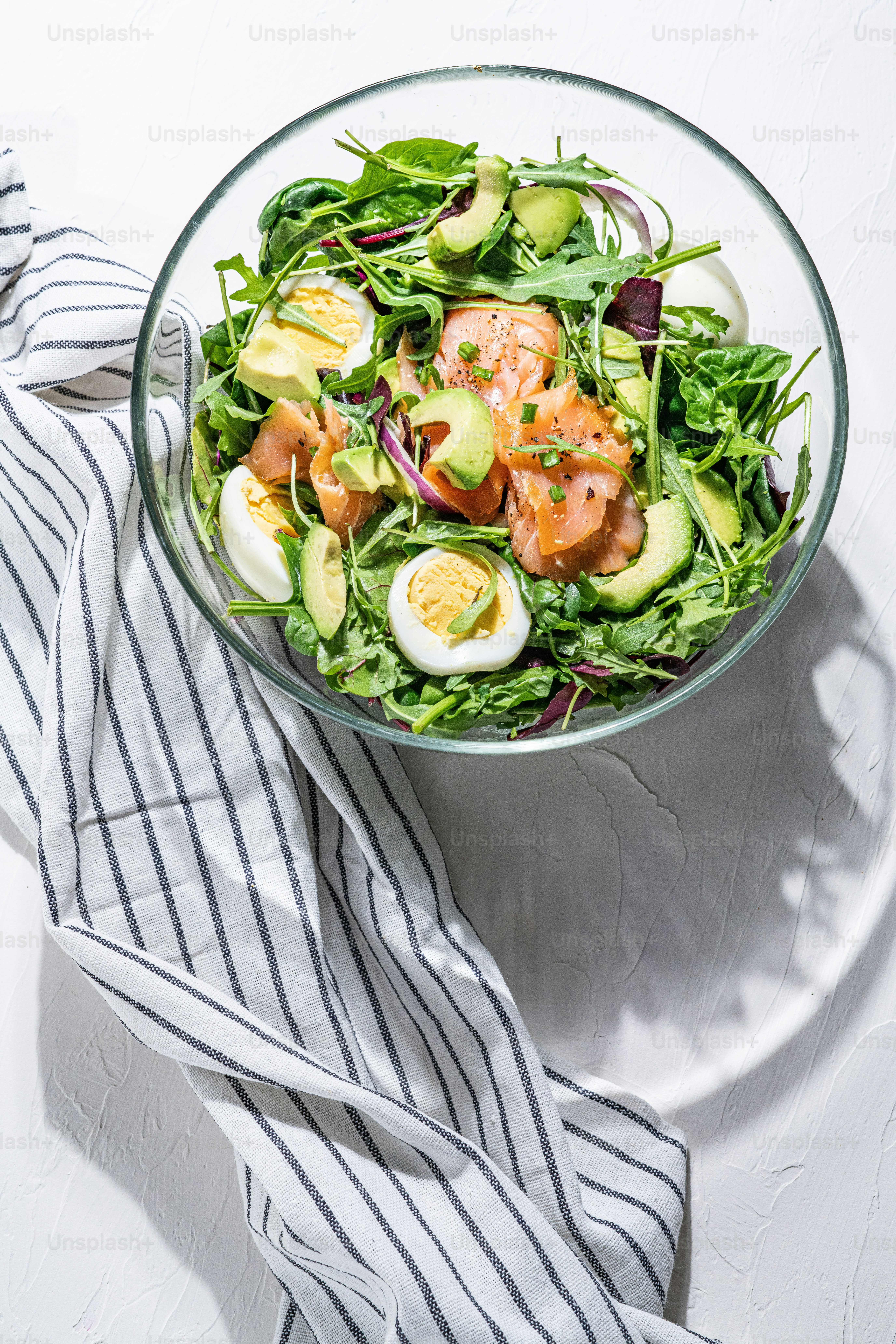 a glass bowl filled with a salad on top of a table