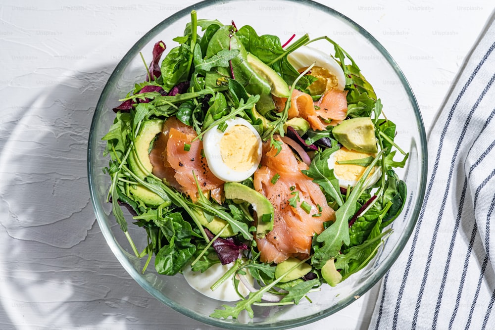 a glass bowl filled with a salad topped with hard boiled eggs