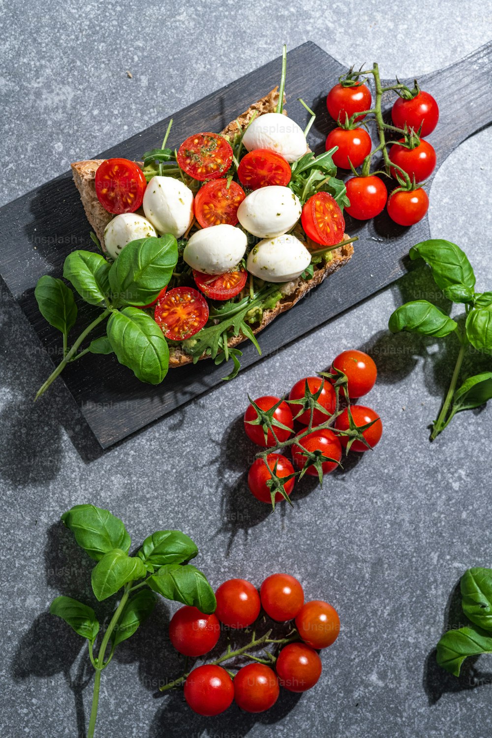 tomatoes, mozzarella and basil on a cutting board