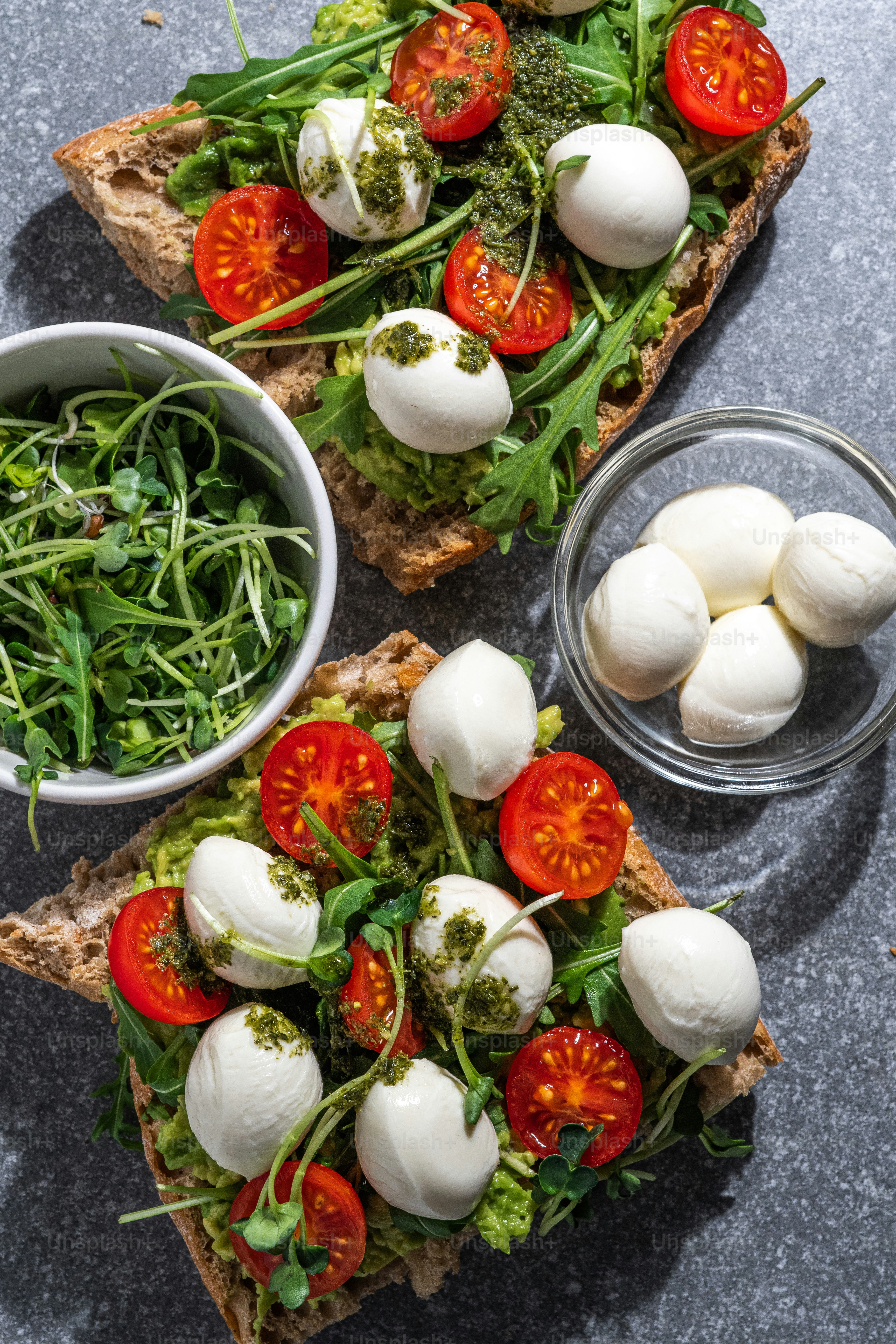 two slices of bread topped with mozzarella and cherry tomatoes