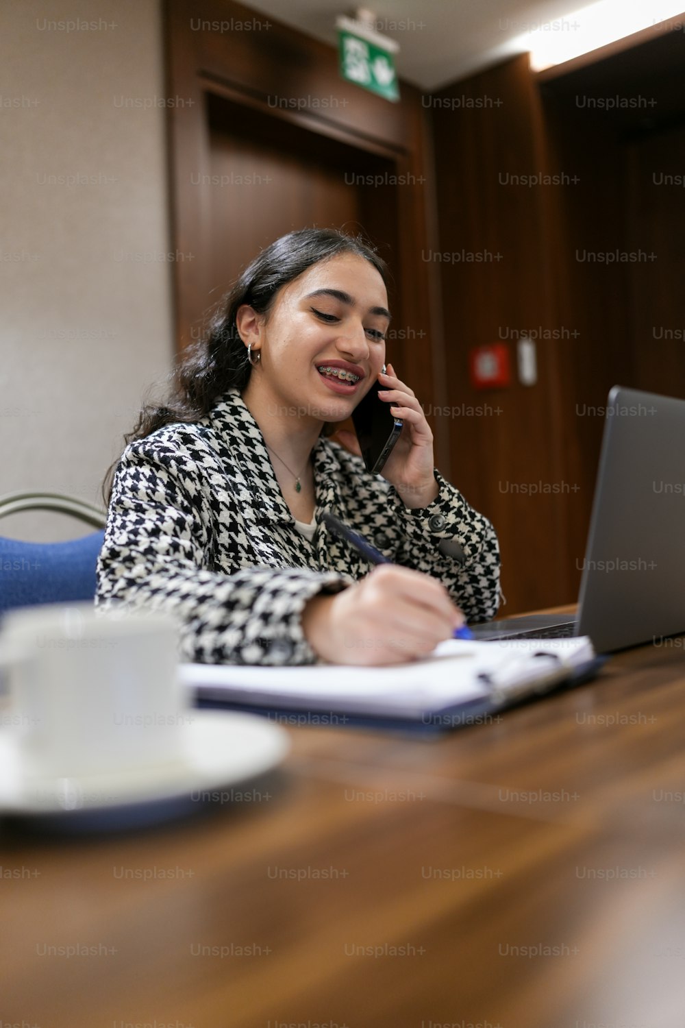 a woman sitting at a table talking on a cell phone