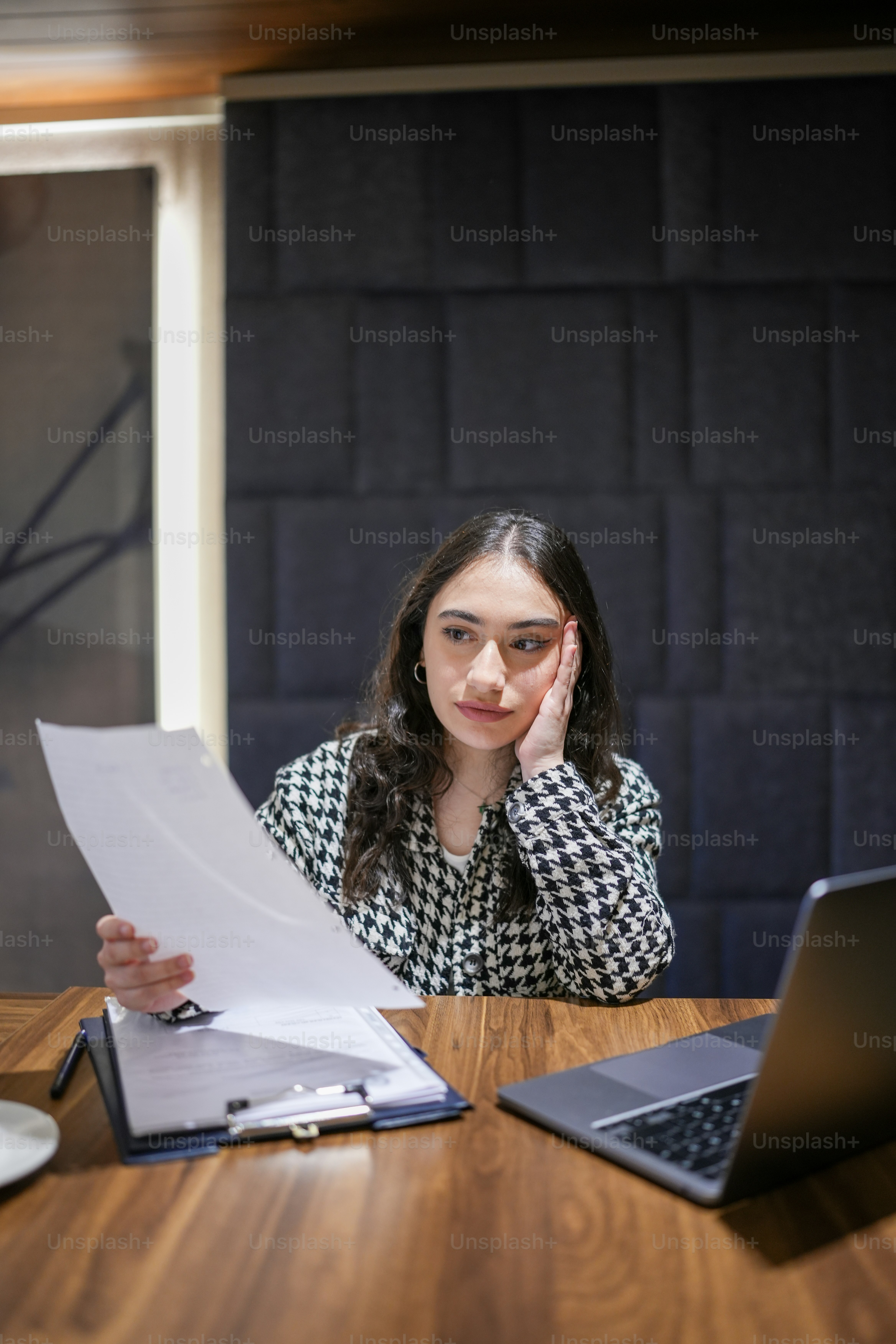 a woman sitting at a table in front of a laptop computer