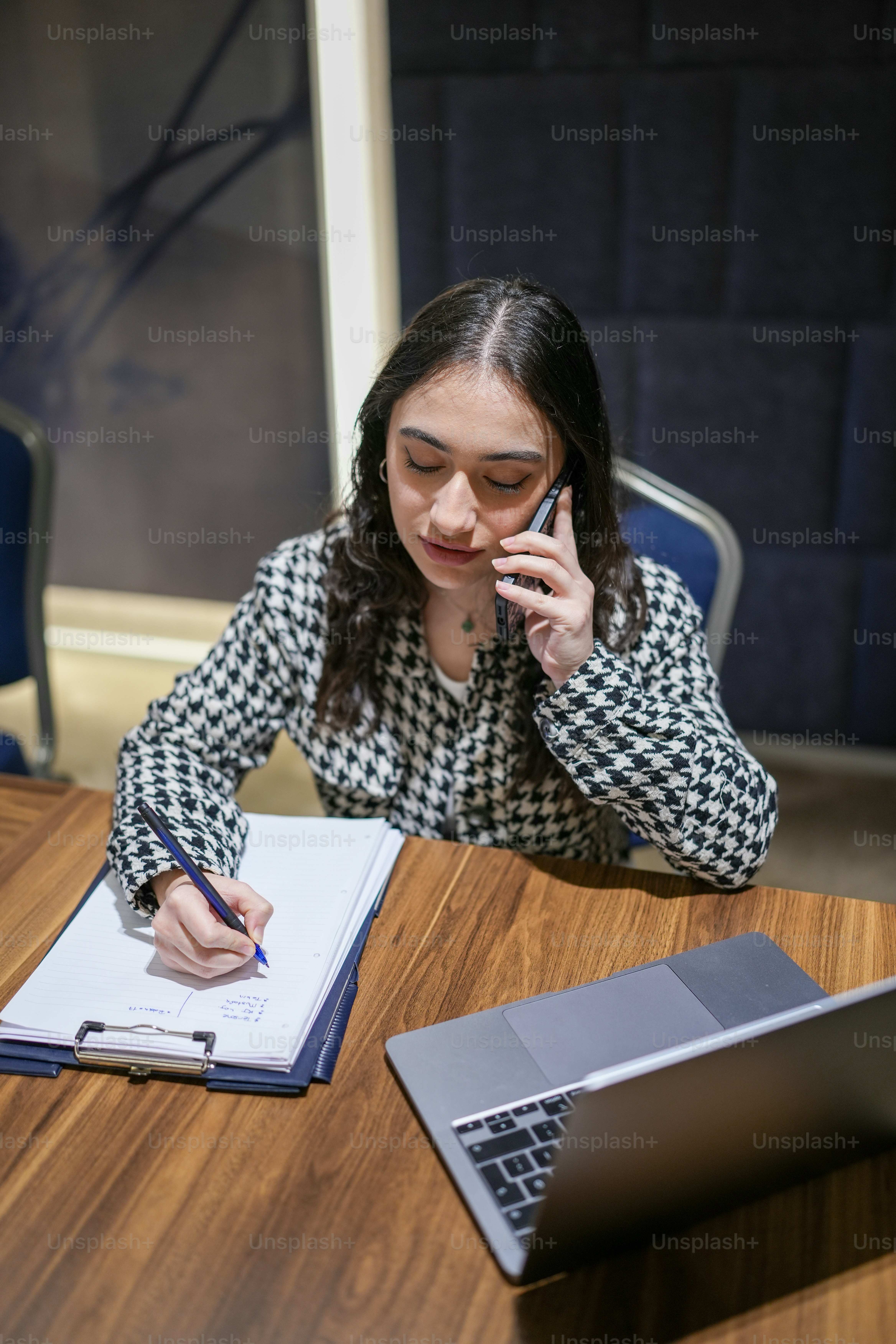a woman sitting at a table talking on a cell phone