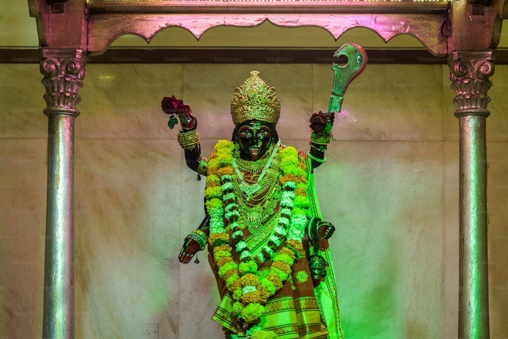 a statue of a person dressed in green and yellow