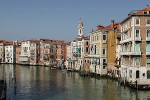 a waterway with buildings and a clock tower in the distance
