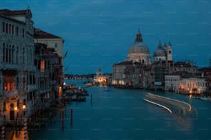 a view of a canal at night with a church in the background