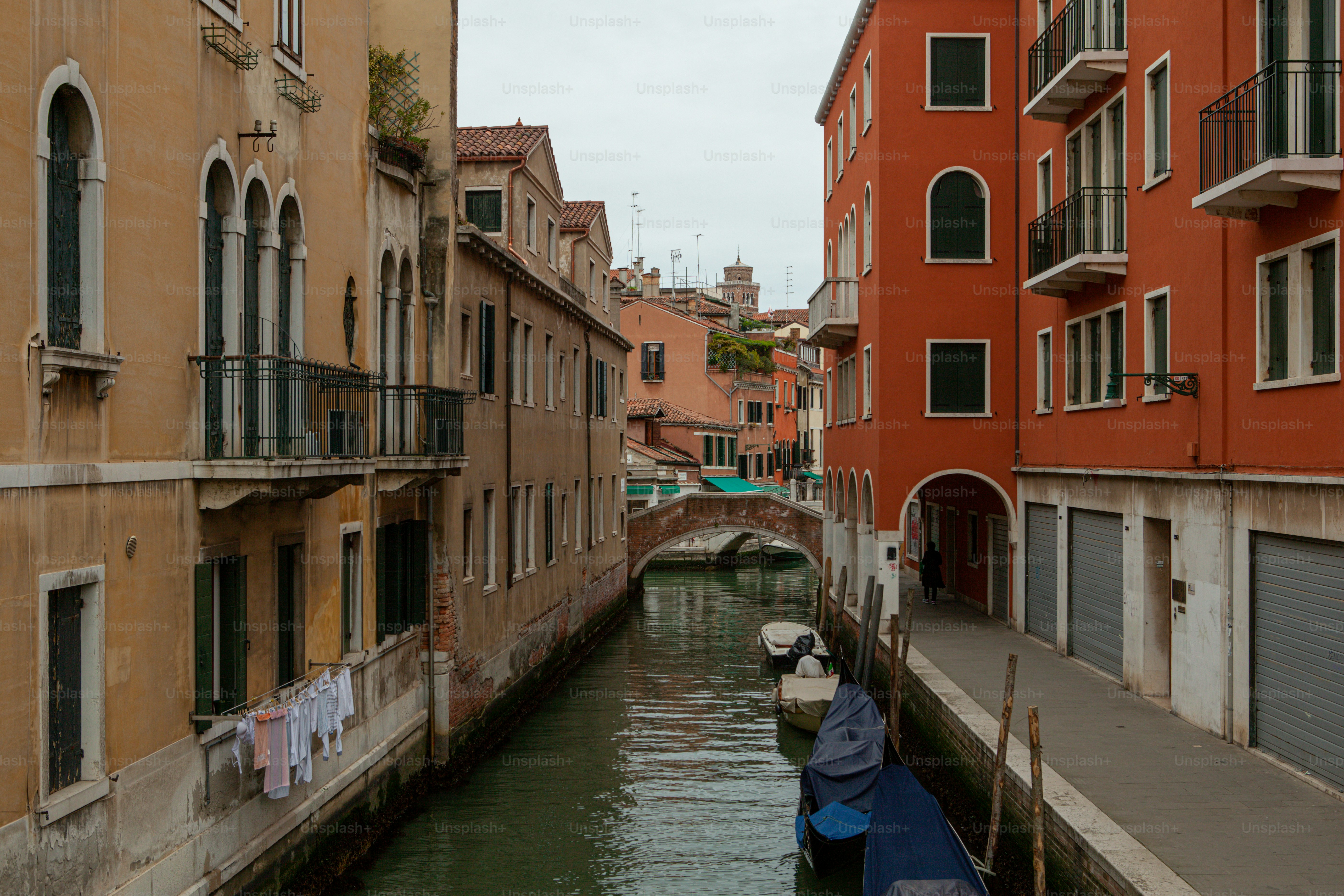 a narrow canal in a city next to tall buildings