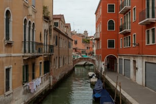 a narrow canal in a city next to tall buildings