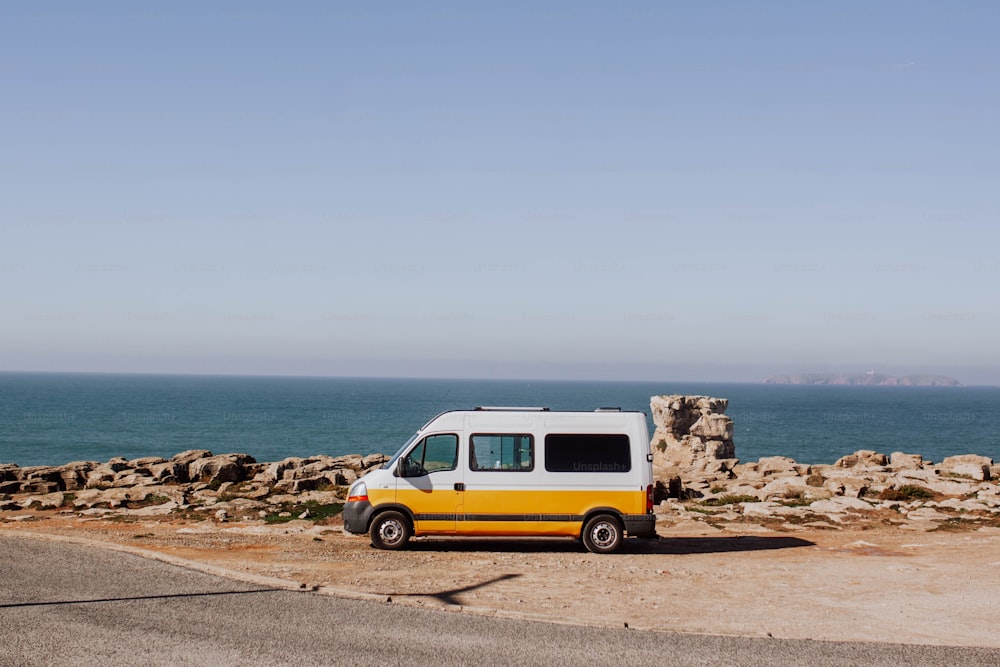 uma van estacionada ao lado de uma estrada perto do oceano
