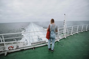 une personne debout sur un bateau regardant l’océan