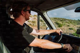 a man driving a truck on a dirt road