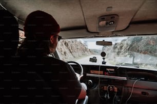 a woman driving a car on a mountain road