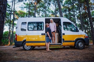 a man and a woman standing in the open door of a van