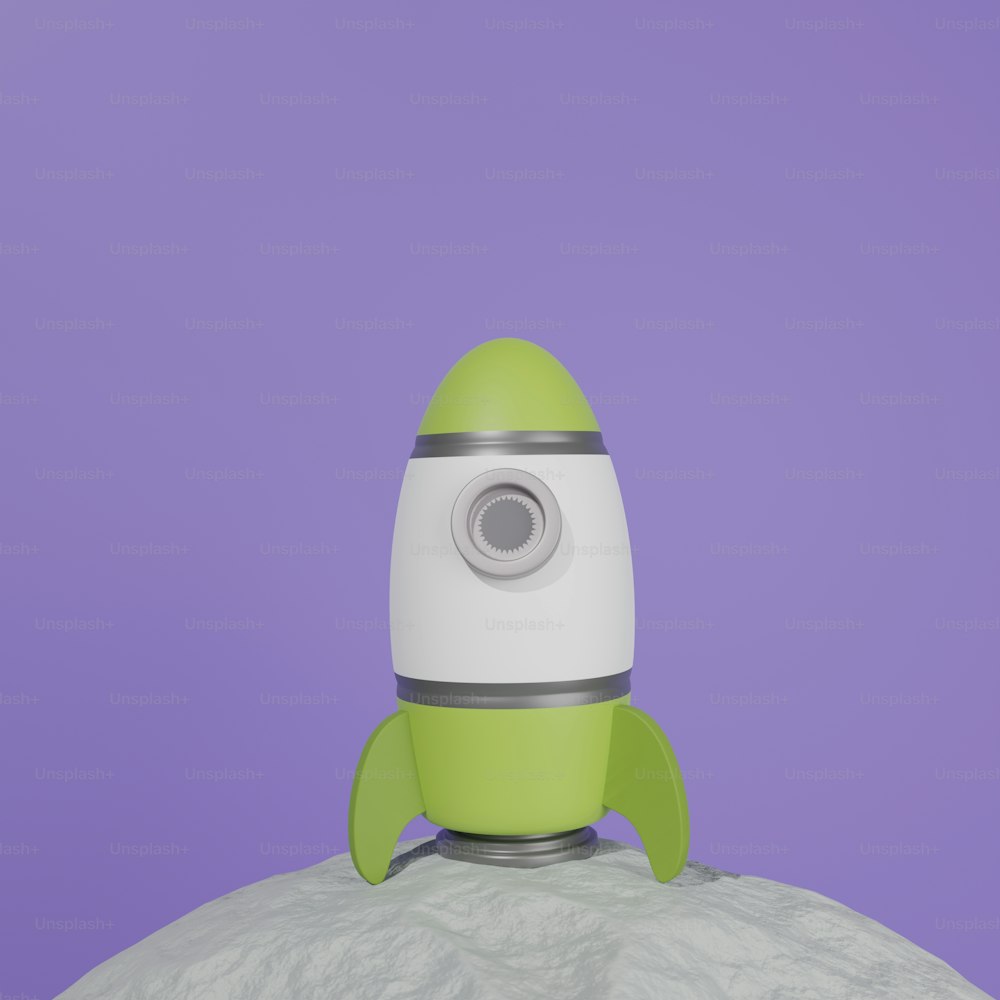 a green and white rocket ship sitting on top of a rock