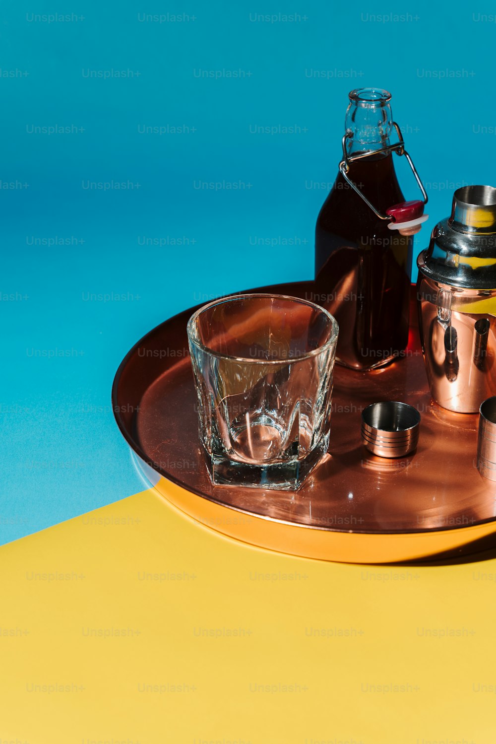a metal tray with a glass and a bottle on it