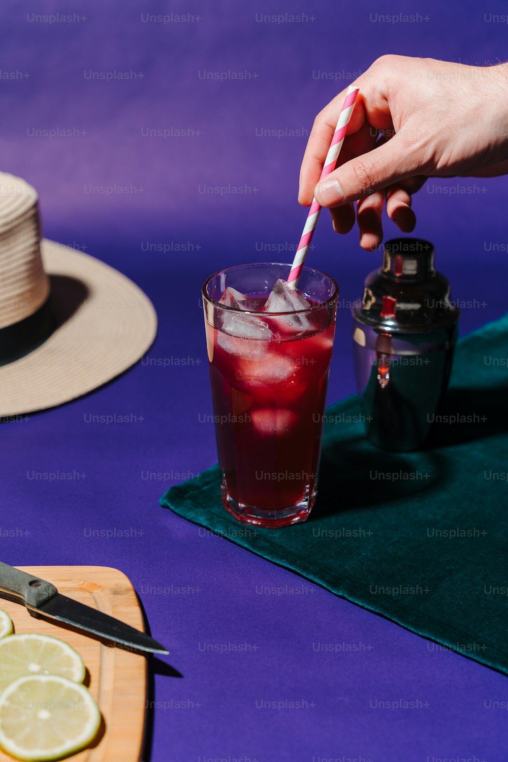 a person holding a straw near a drink