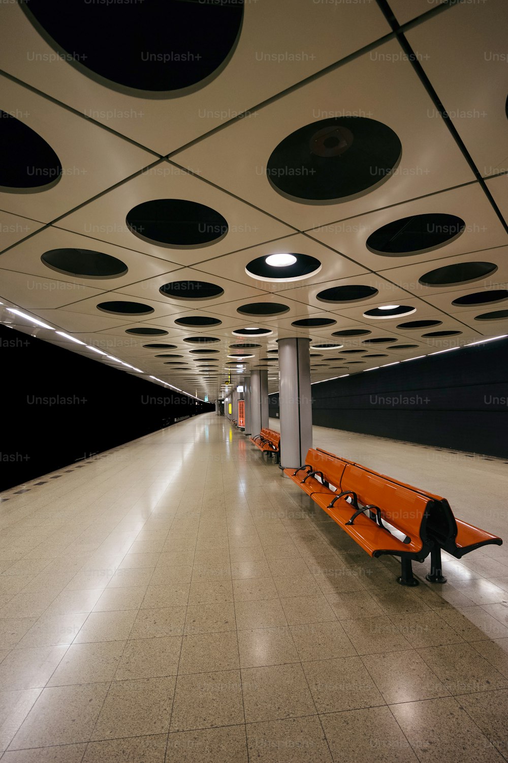 an orange bench sitting in the middle of a hallway