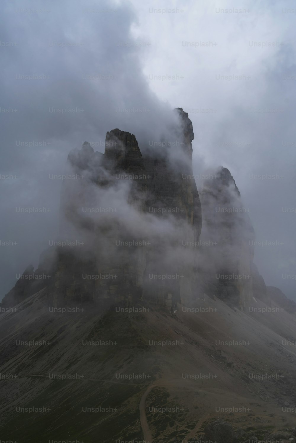 a mountain covered in fog and clouds on a cloudy day