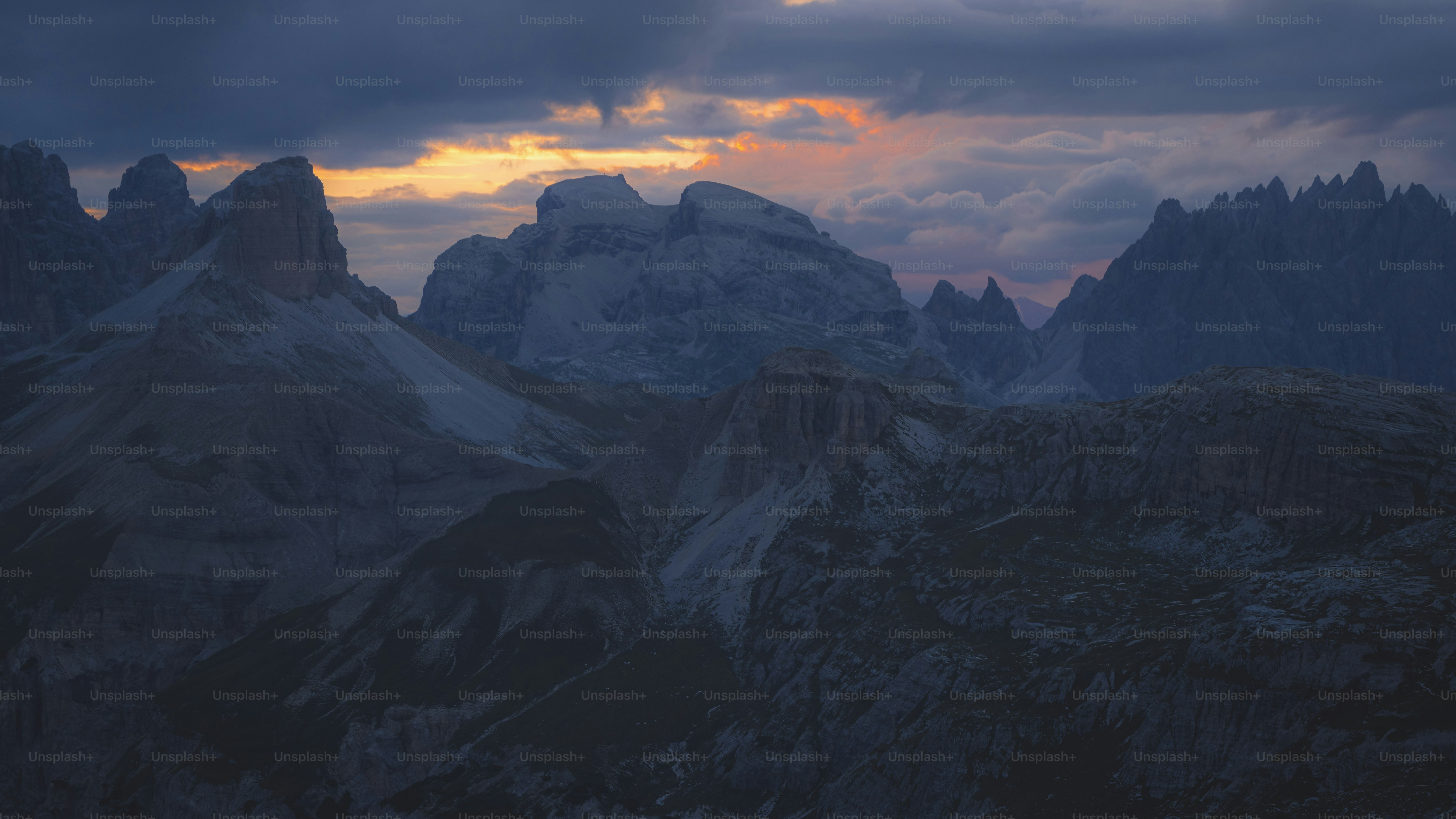 the sun is setting over a mountain range