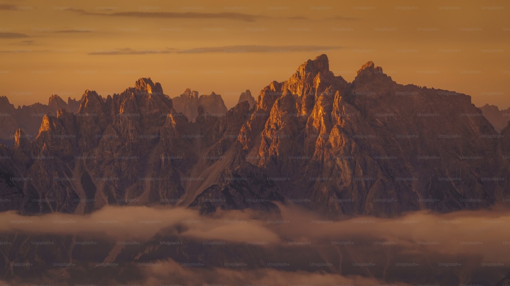 a view of a mountain range with clouds below