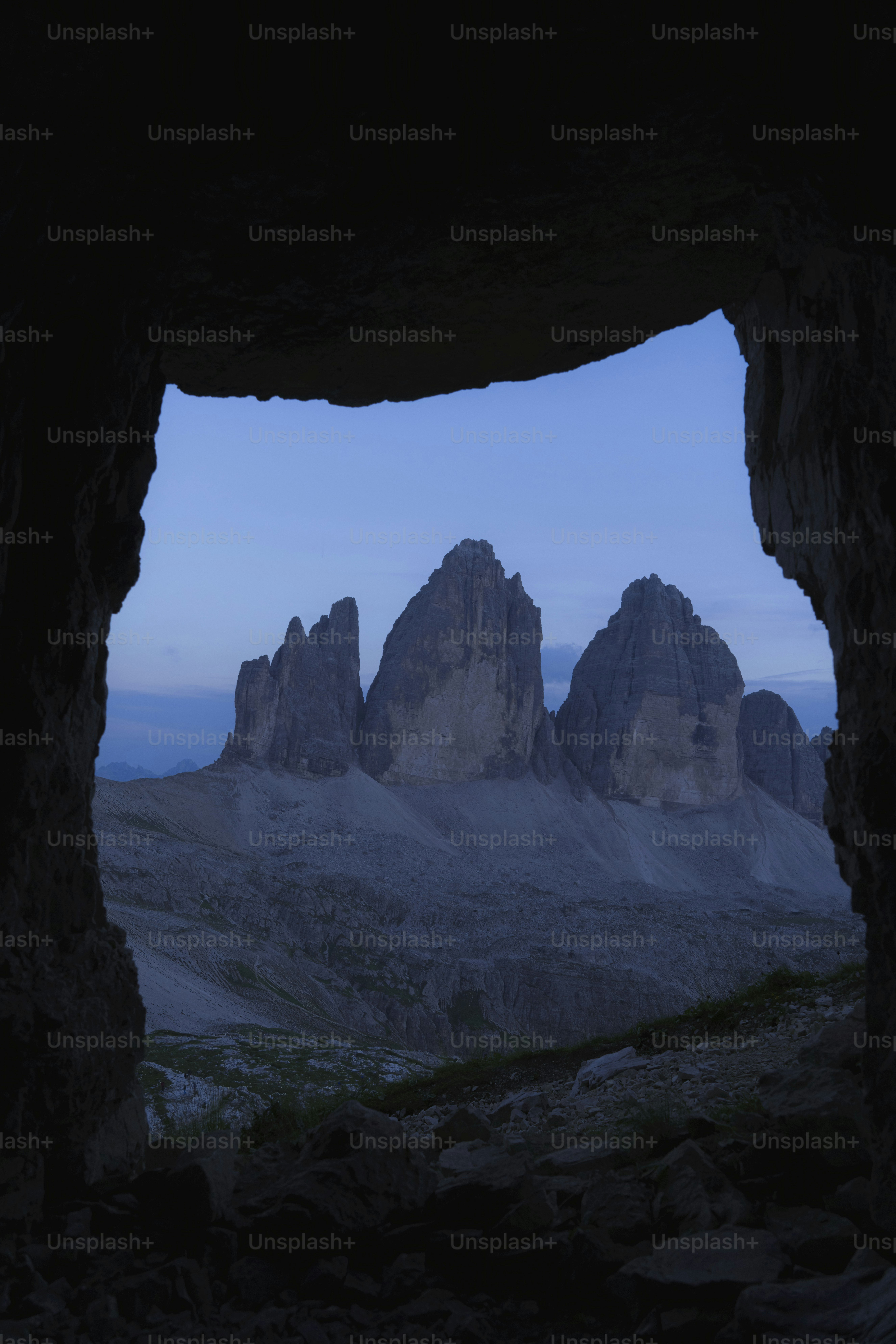 a view of a mountain range through a cave