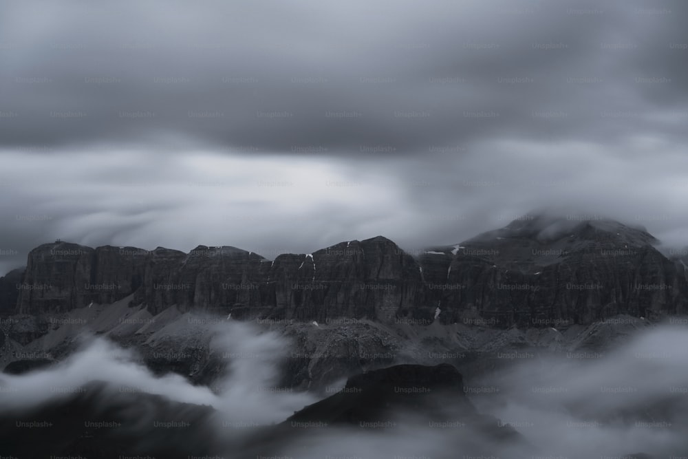 a mountain covered in clouds under a cloudy sky