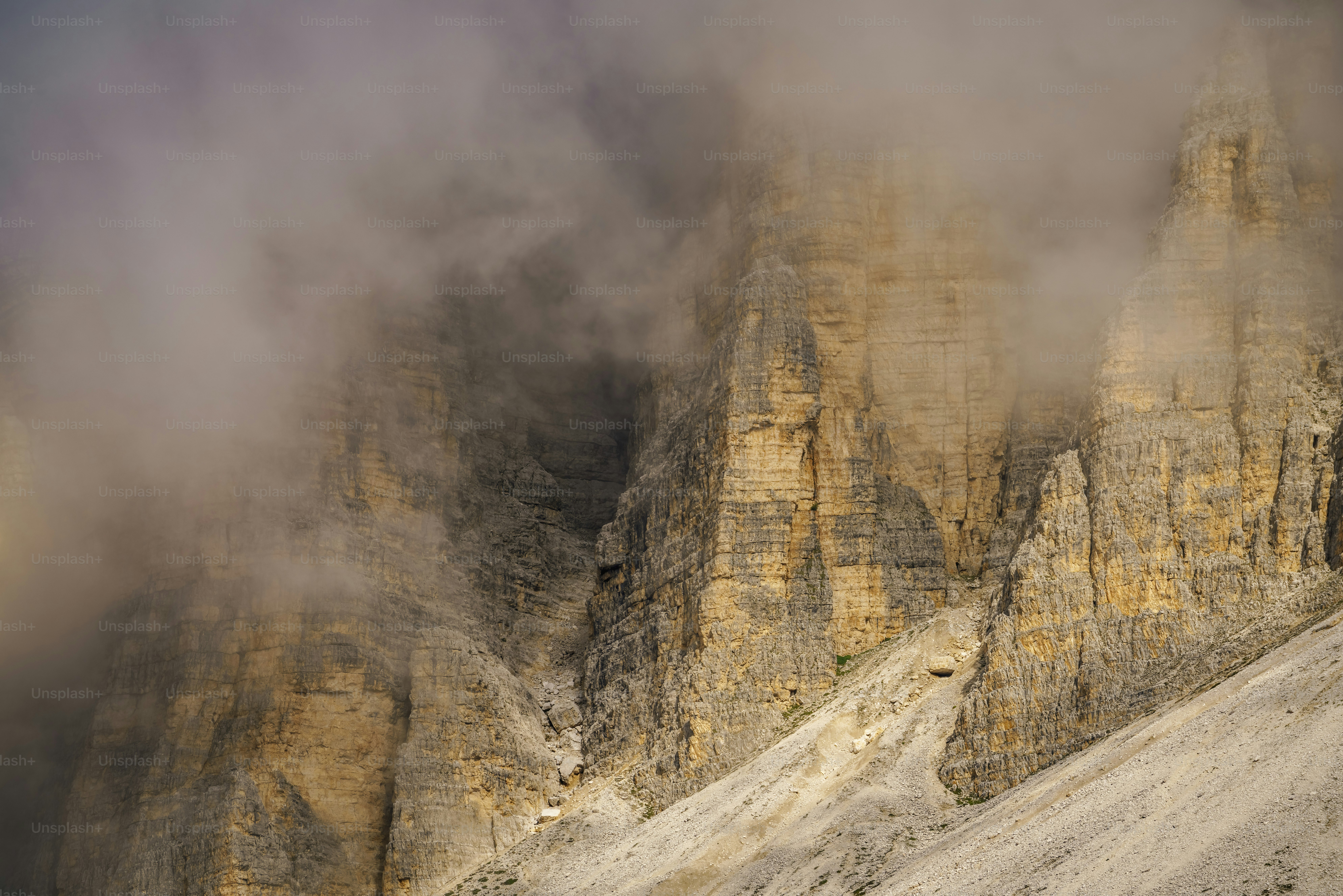 Un groupe de montagnes couvertes de brouillard et de nuages