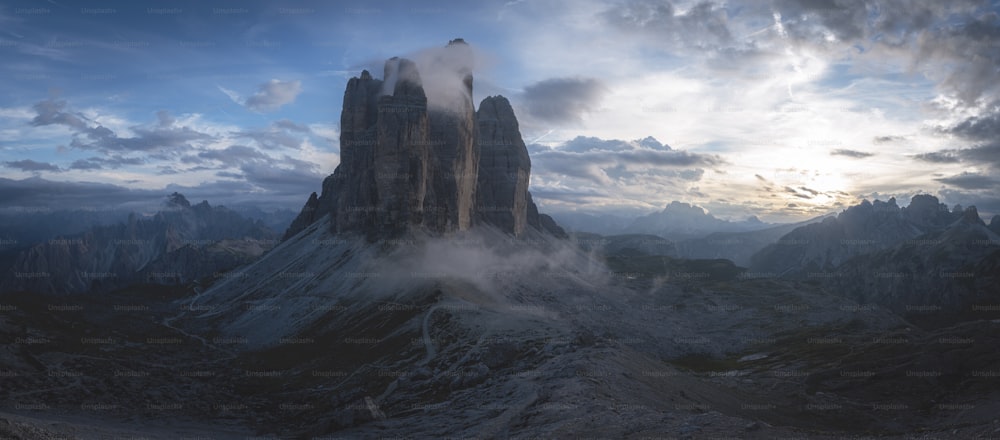 a very tall mountain with some clouds in the sky