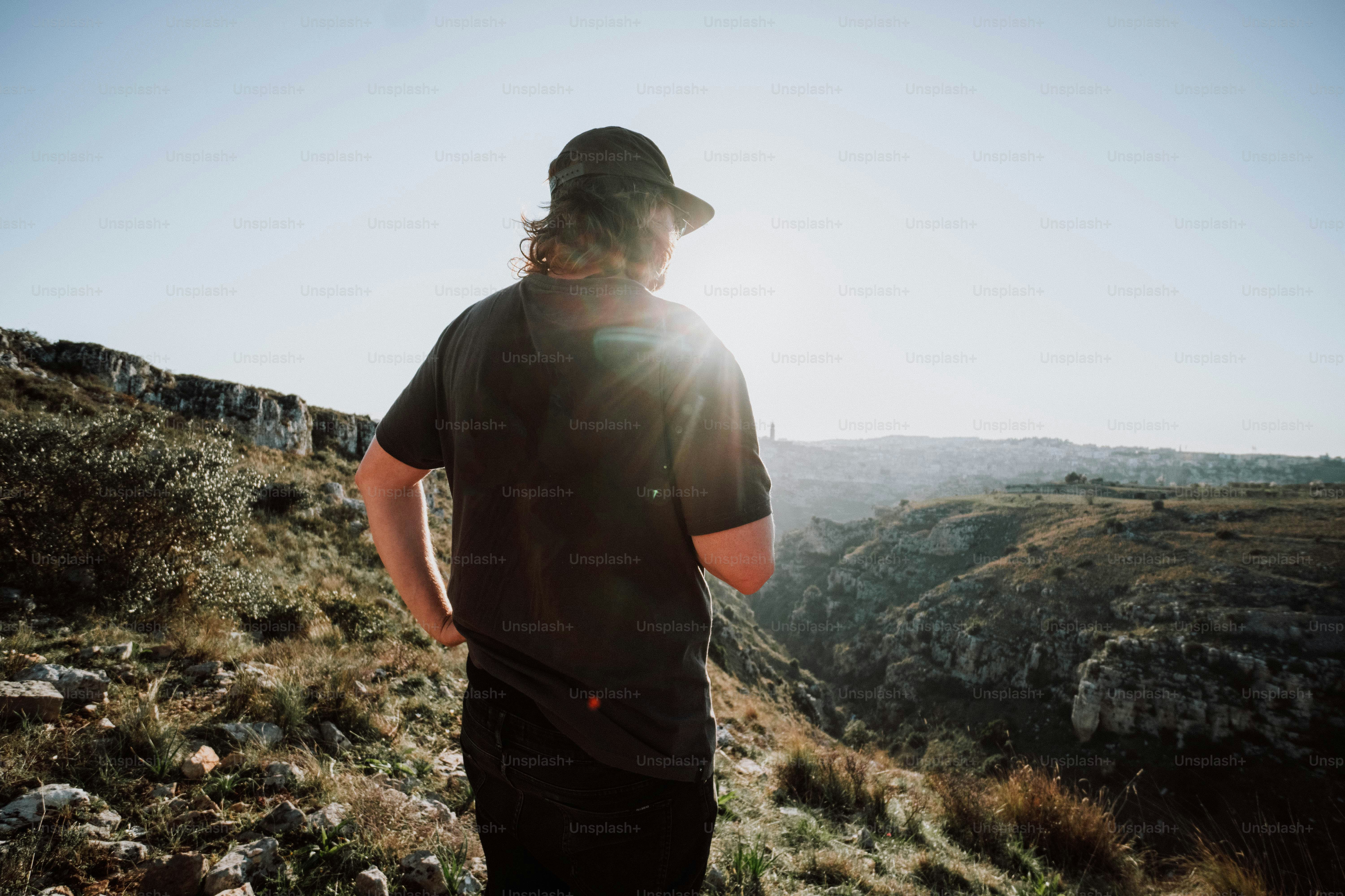 a man standing on top of a lush green hillside