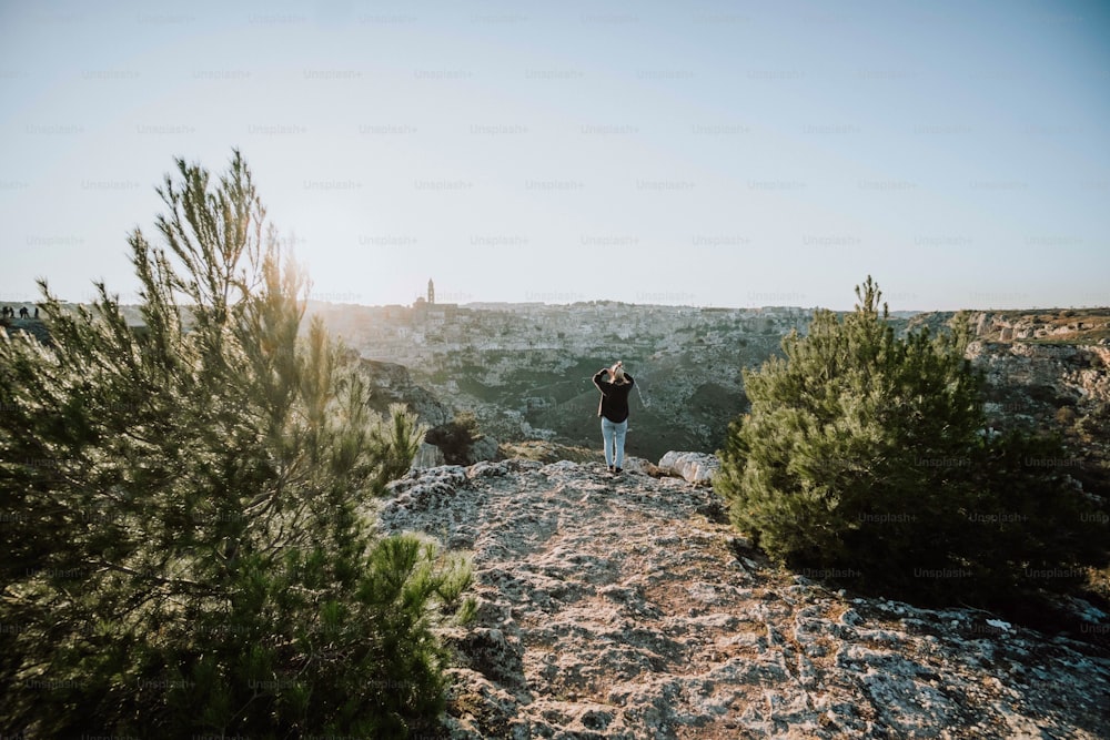 Un homme debout au sommet d’une colline rocheuse