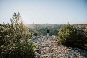 a man standing on top of a rocky hillside