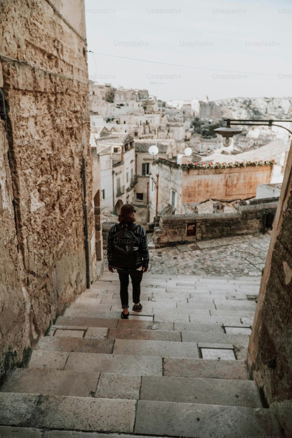 a person walking down a stone street next to a building