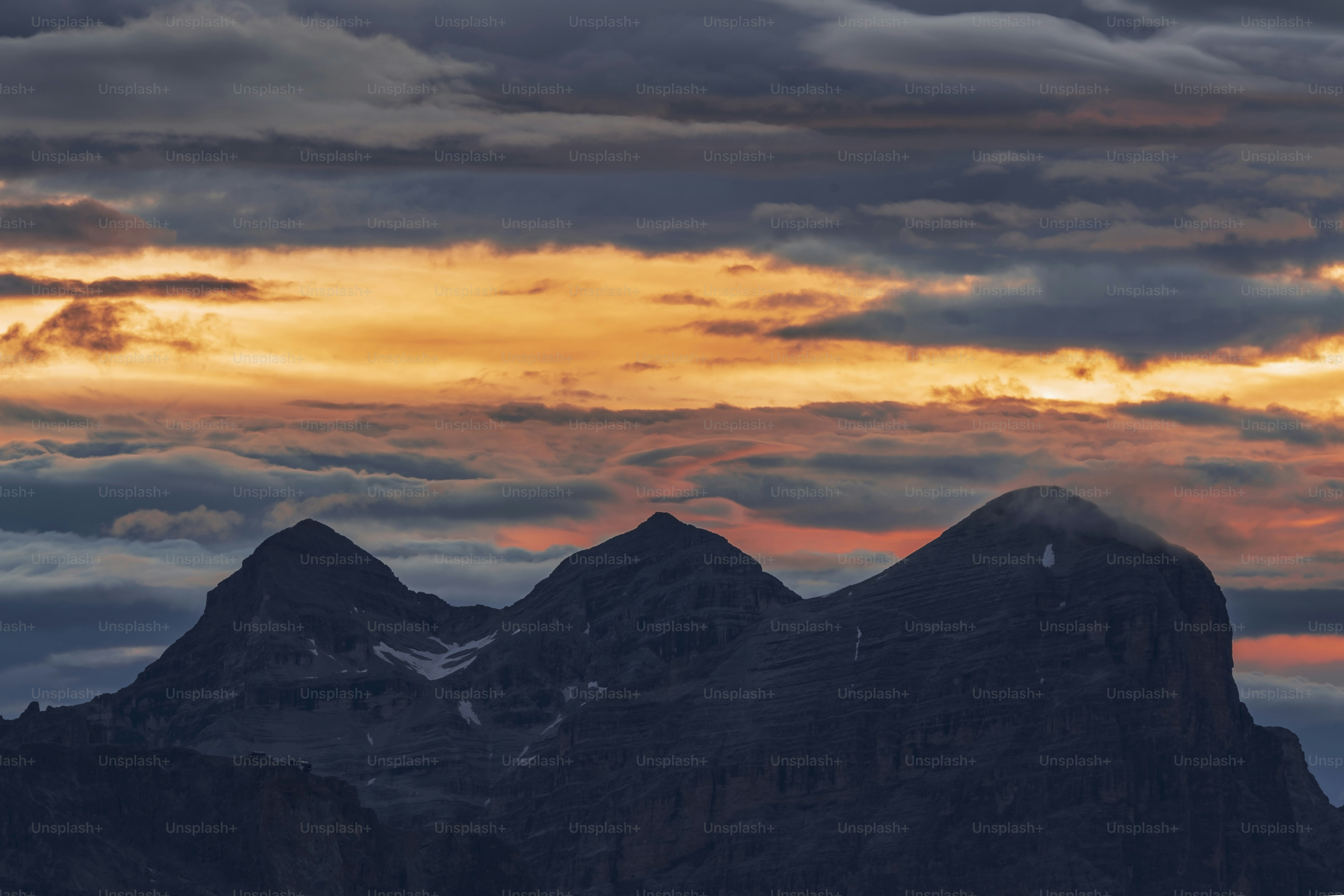 the sun is setting behind a mountain range
