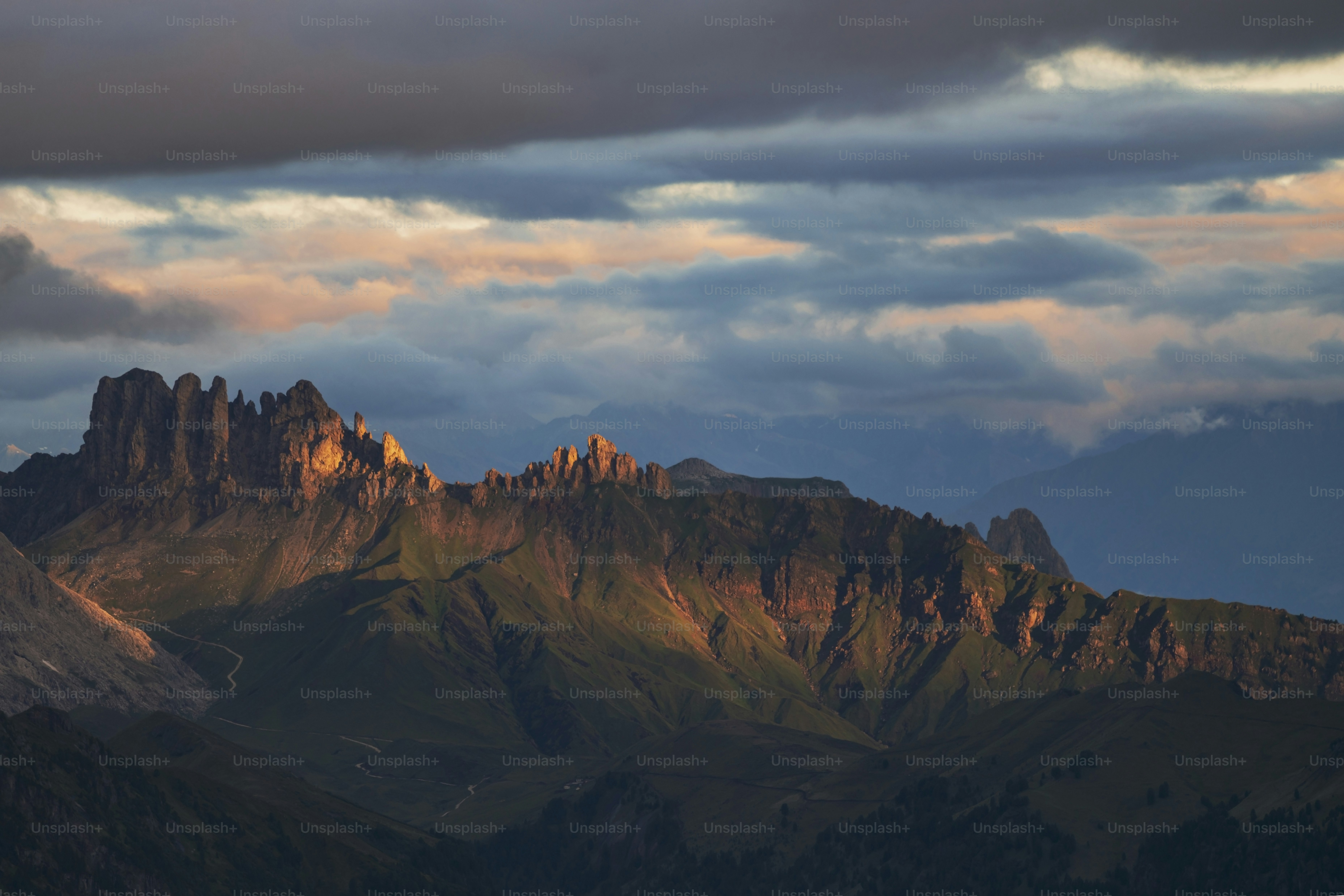 a mountain range with a few clouds in the sky