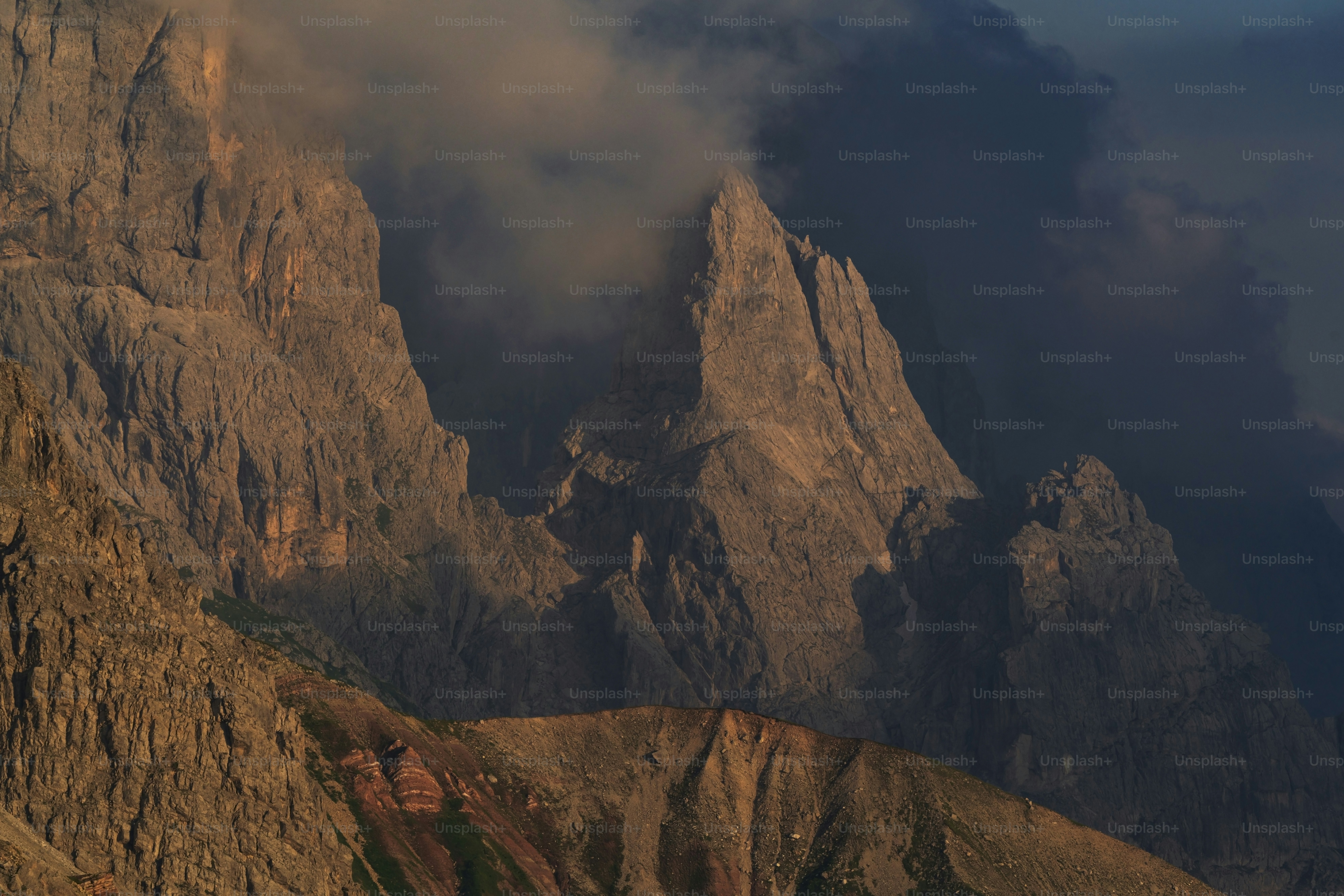 a very tall mountain with some clouds in the sky