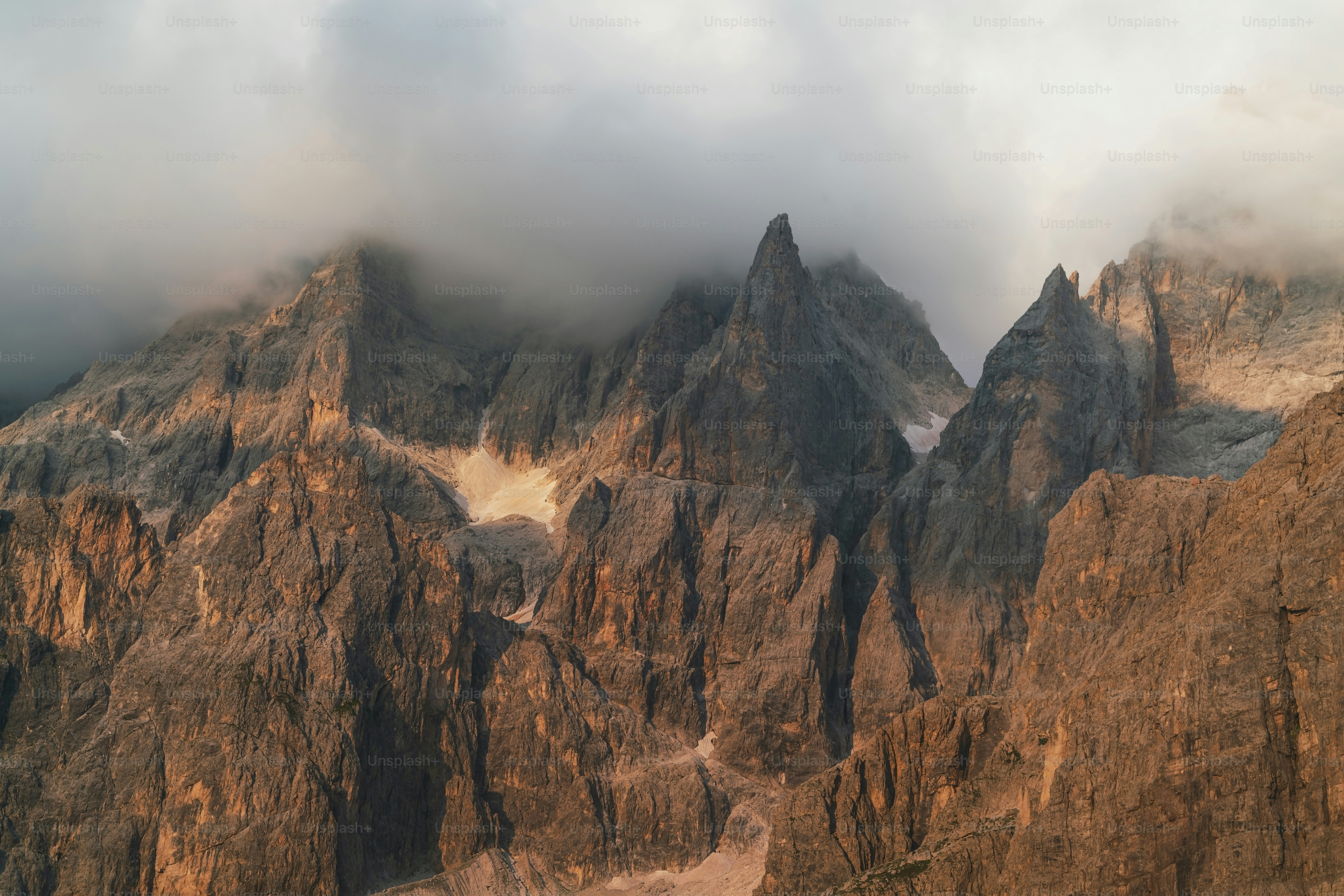 a very tall mountain with some clouds in the sky