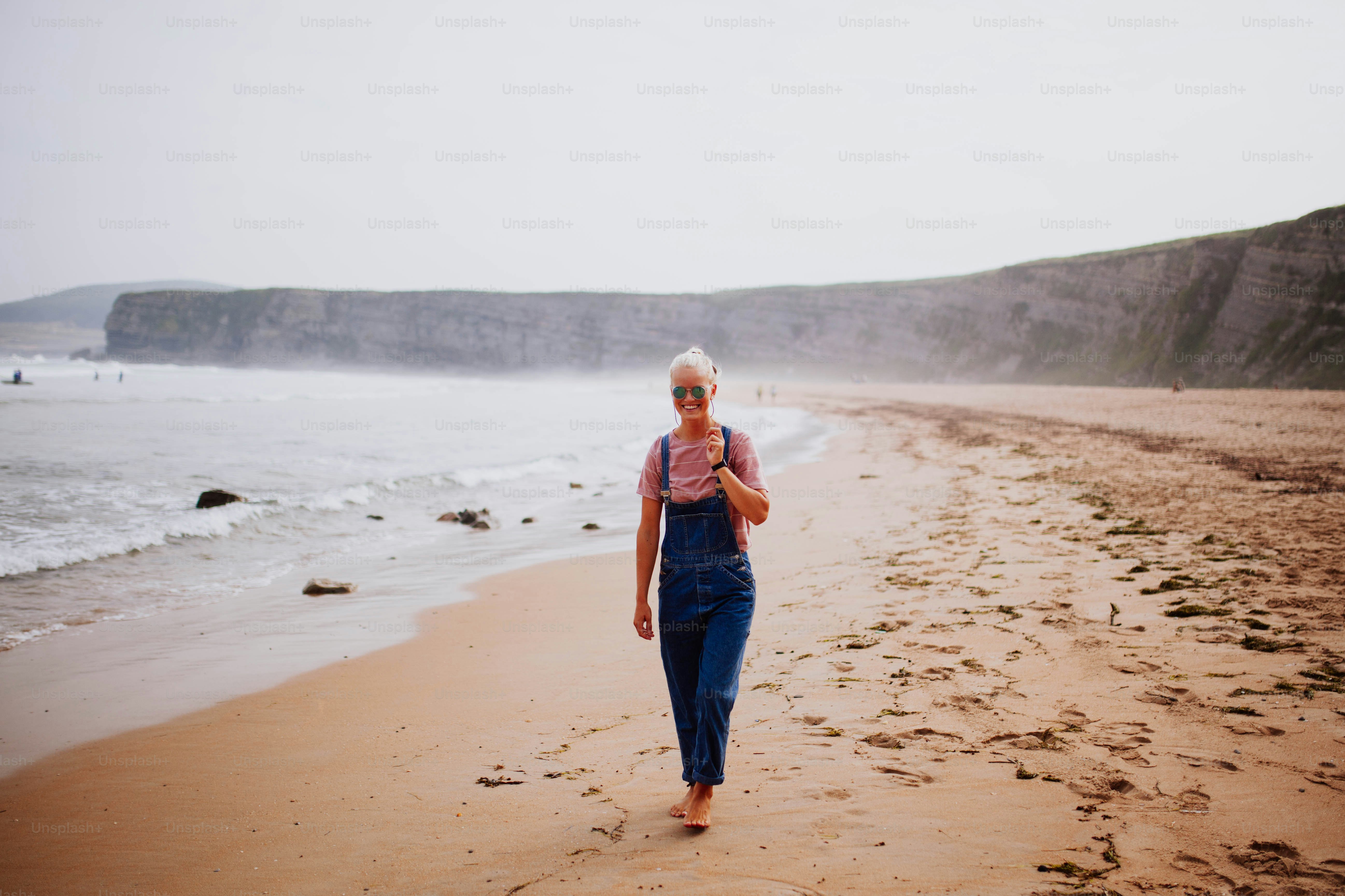 Une femme marchant sur une plage au bord de l’océan