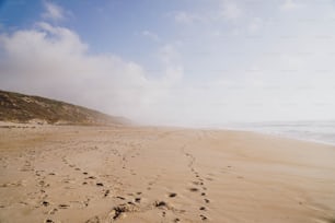 a sandy beach with footprints in the sand