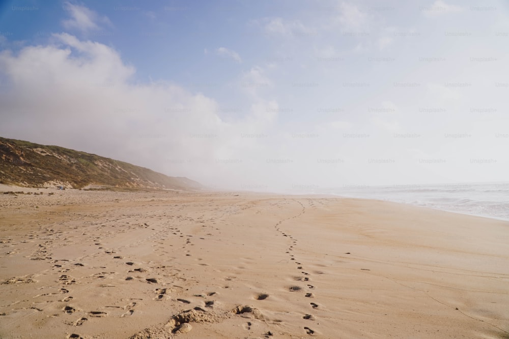 a sandy beach with footprints in the sand