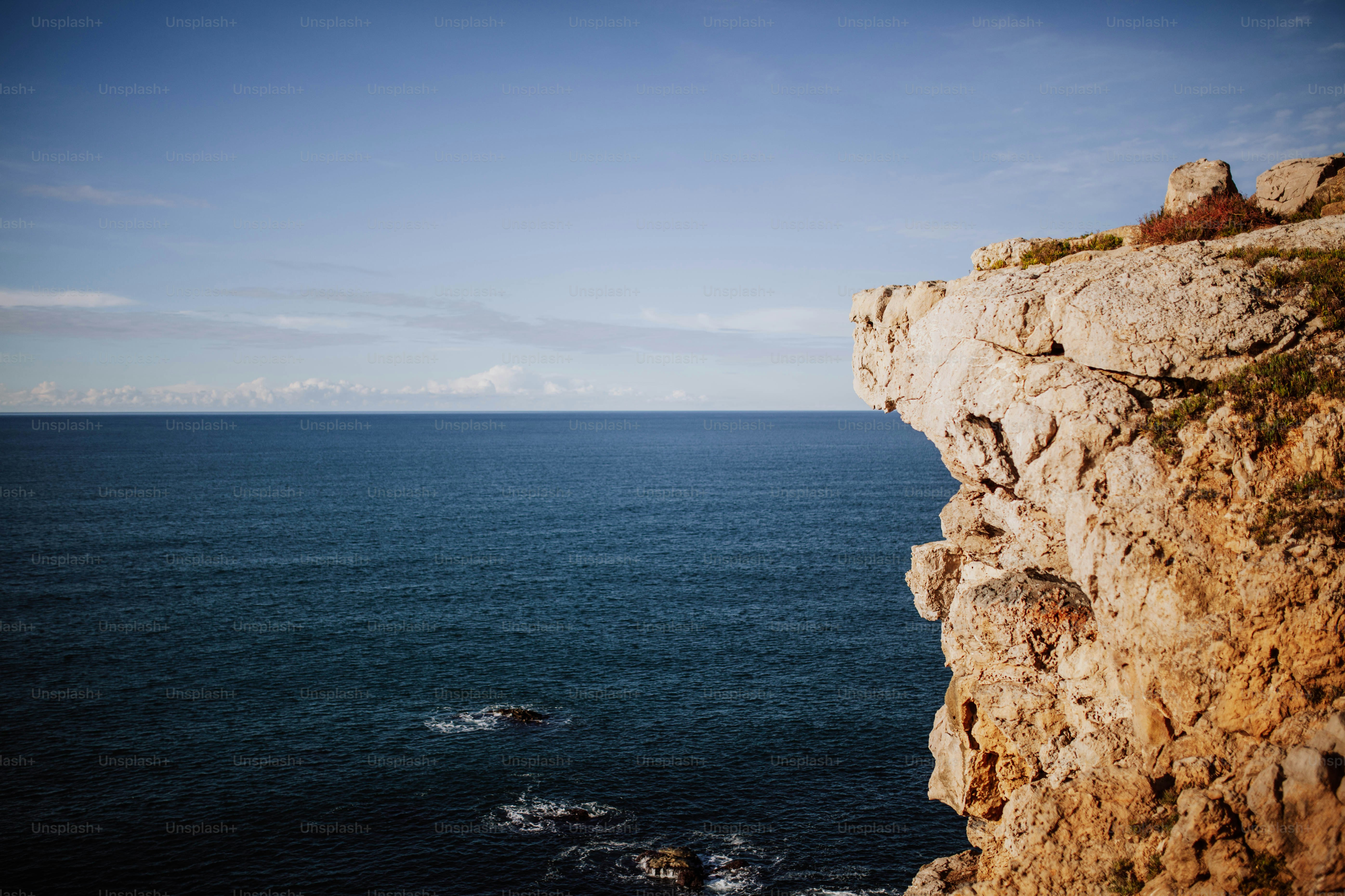 a rocky cliff overlooks a body of water